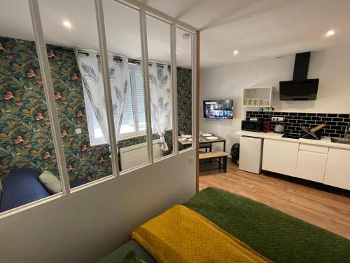 Il comprend un salon avec une grande fenêtre et une cuisine. dans l'établissement La Nouvelle-Orléans - hyper-centre- 2mn SNCF - Wi-Fi Netflix gratuit, à Niort