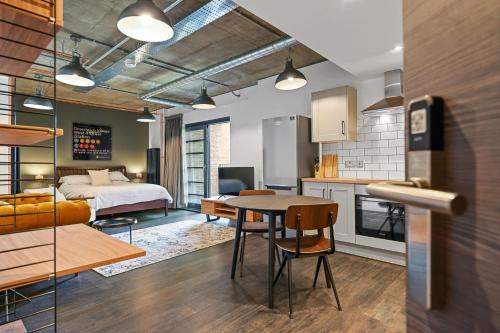 a kitchen and living room with a bed and a table at Modern and Chic Apartments at Ferrum near Wembley Park in London