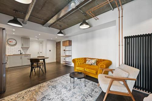 a living room with a yellow couch and a kitchen at Modern and Chic Apartments at Ferrum near Wembley Park in London