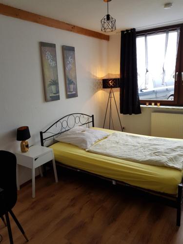 a bedroom with a bed and a table and a window at Pension Werner Nagel in Wewelsfleth