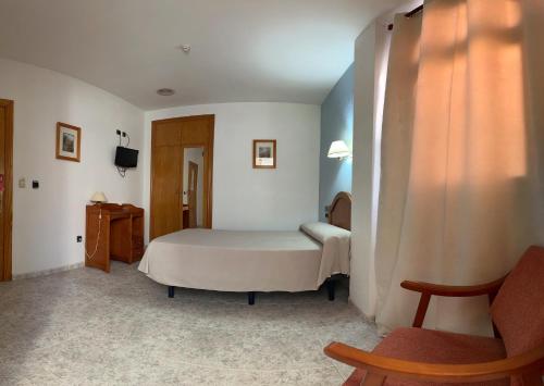 a bedroom with a bed and a chair in it at Hospedium Hotel Twist in Torredonjimeno