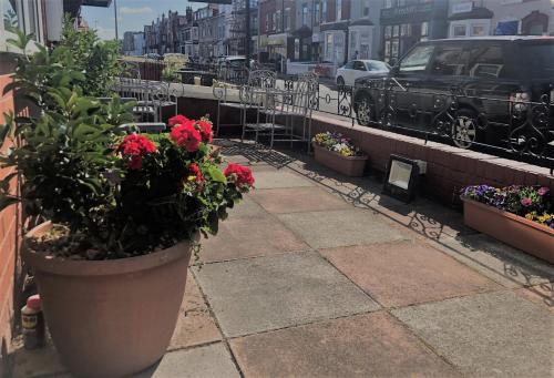 a patio with flowers in pots on a building at Ultimate Family Guest House in Blackpool