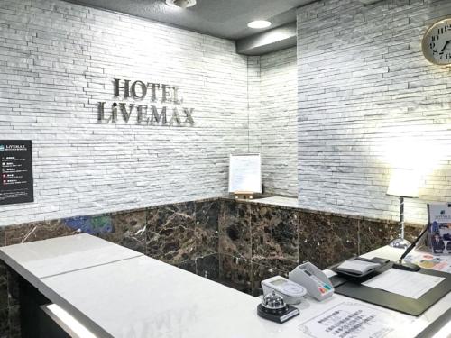 an office with a desk with a hotel hyuana sign on the wall at HOTEL LiVEMAX BUDGET Nagoya Taikodori in Nagoya