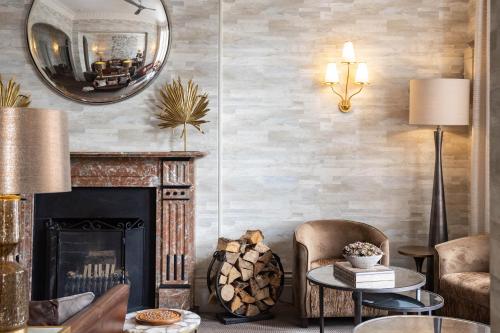 a living room with a fireplace and a mirror at Lincombe Hall Hotel & Spa - Just for Adults in Torquay