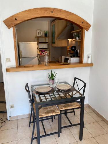 Il dispose d'une cuisine et d'une table à manger avec 2 chaises. dans l'établissement Appartement Cosy avec jardin privatif et garage, à Fontainebleau