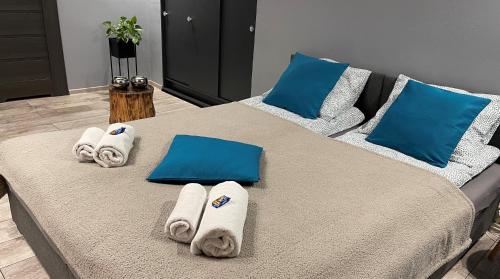 a bed with blue pillows and towels on it at Apartamenty Pod Uwalonym Dębem in Jeżów Sudecki