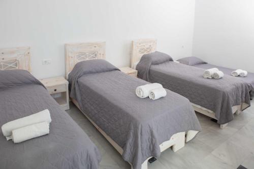 a room with three beds with towels on them at Cyclades Hotel in Karterados
