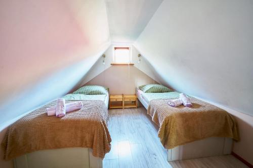 a attic room with two beds with pink bows at Domek Pod Lasem in Polanica-Zdrój