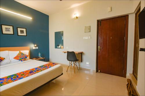 1 dormitorio con 1 cama y puerta de madera en FabHotel Sasti Inn, en Chennai