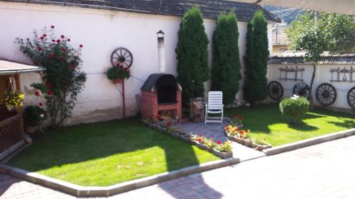a small garden with a fireplace in the side of a house at Casa Lenke in Săcele