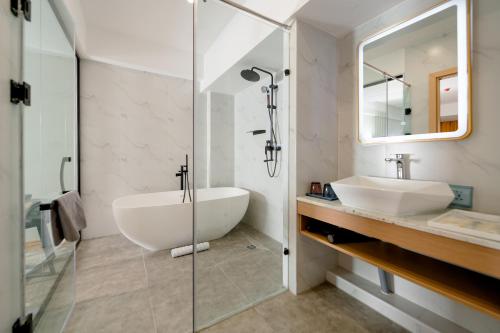 a bathroom with a tub and a sink and a mirror at MIllennium Plaza Hotel & Mall Ulaanbaatar in Ulaanbaatar