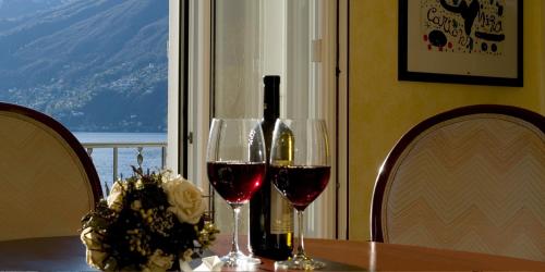 una mesa con dos copas de vino y una botella de vino en Ascona: Nostrana Apt. 2, en Ascona