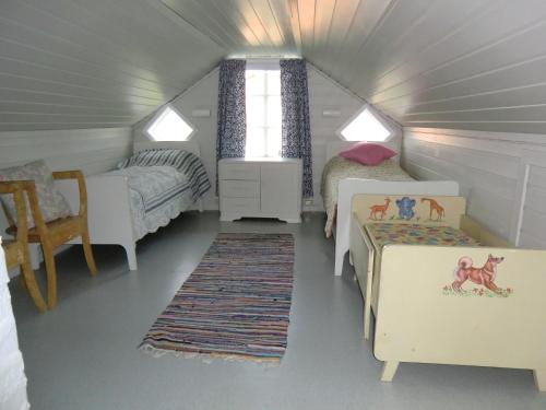 a small bedroom with two beds and a window at Hov Feriehus in Gimsøy