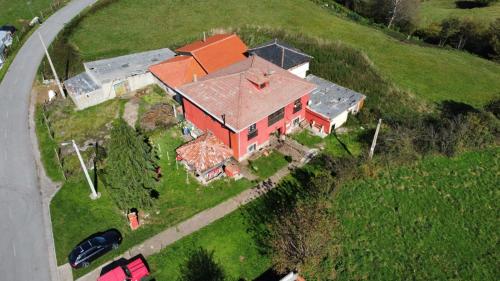 an aerial view of a large red house on a hill at Casa Faruxo in Cangas del Narcea