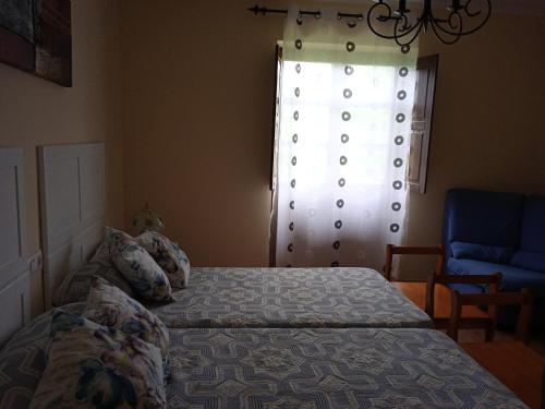 a bedroom with a bed in front of a window at Casa Faruxo in Cangas del Narcea