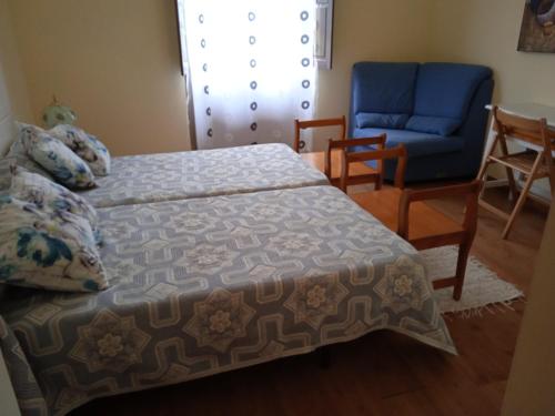 a bedroom with a bed and a chair and a couch at Casa Faruxo in Cangas del Narcea