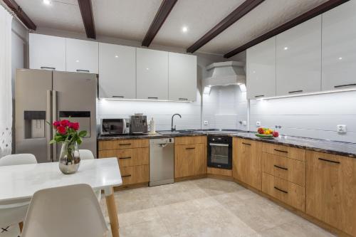 a kitchen with white cabinets and a vase of flowers on a table at Zarzecze 27A in Augustów