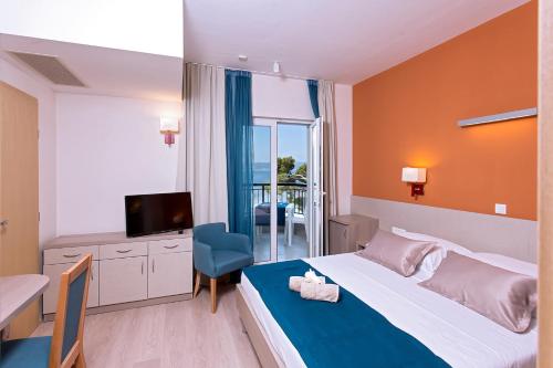 a bedroom with a bed and a table and a television at Apartments Villa Loznica in Brela