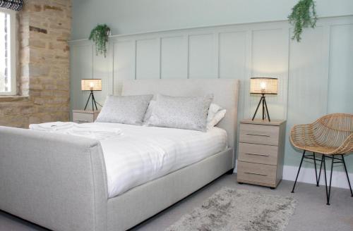 um quarto com uma cama branca e 2 candeeiros em Heritage Serviced Suites - Serviced Apartments em Huddersfield