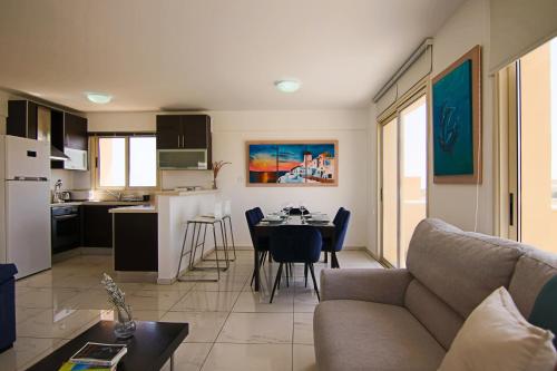 a living room and kitchen with a couch and a table at Seaside Luxury Flat Pervolia in Perivolia