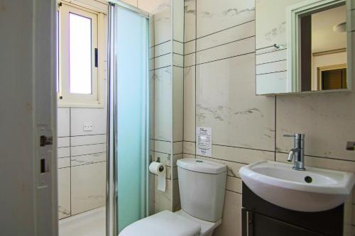 łazienka z toaletą i umywalką w obiekcie Phaedrus Living Seaside Luxury Flat Pervolia w mieście Periwolia