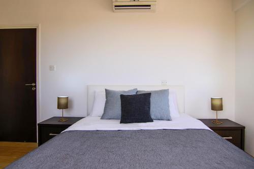 1 dormitorio con 1 cama grande y 2 lámparas en las mesas en Phaedrus Living Seaside Luxury Flat Pervolia en Pervolia