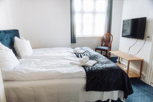 a bedroom with a bed with a white flower on it at Hotel Lidenlund in Lemvig