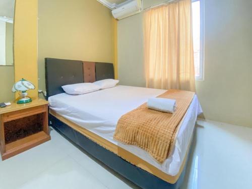 a bedroom with a bed and a table and a window at Transisco Hotel Sorowako Mitra RedDoorz in Saroako