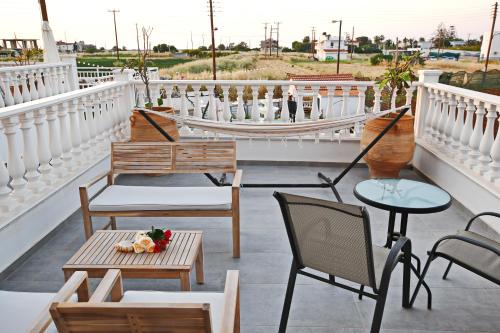 a balcony with chairs and tables on a building at Olympus Studios in Malia