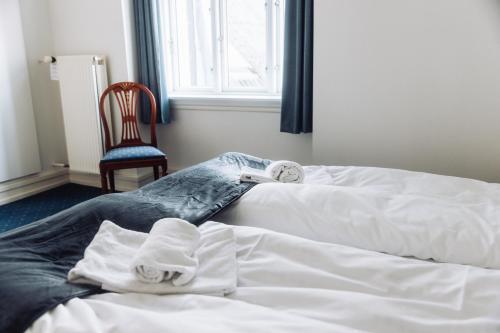 a hotel room with two beds with towels on them at Hotel Lidenlund in Lemvig