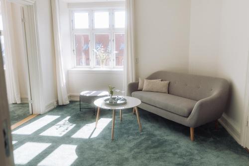 a living room with a couch and a table at Hotel Lidenlund in Lemvig