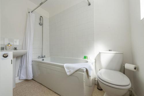 a white bathroom with a toilet and a bath tub at Contractors & Leisure & Airport Location & Riverfront in Liverpool