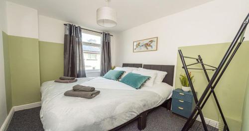 a bedroom with a bed with towels on it at Contractors & Leisure & Airport Location & Riverfront in Liverpool