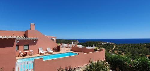 a villa with a swimming pool in front of a house at Villa Cabanas beach in Budens