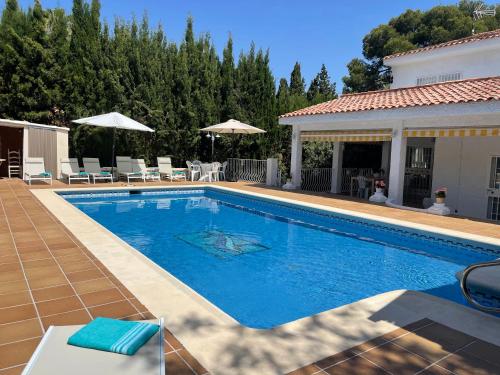 a swimming pool in a yard with a house at Villa Mis 5 Amores con piscina in Benidorm