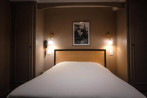 Ένα ή περισσότερα κρεβάτια σε δωμάτιο στο Hôtel Saint-Julien