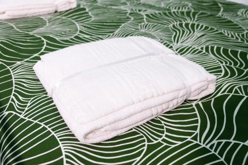 einen Stapel weißer Handtücher auf einem Bett in der Unterkunft Le Dimore di Emilia - Casa Bea in Neapel