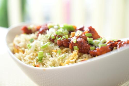 a bowl of rice with meat and green onions at Garden City Hotel Dubai in Dubai