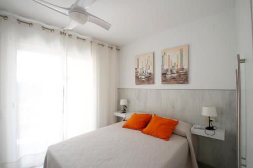 a bedroom with a bed with two orange pillows at Los Pelicanos in Miami Platja