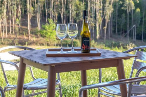a wooden table with two wine glasses on it at Basoan in Mungia