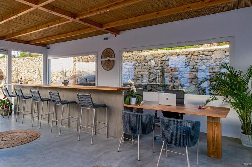 a bar with chairs and a table with a laptop at CASA DI PIETRA MYKONOS in Klouvas