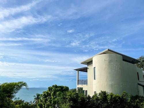 a building on a hill with the ocean in the background at High Life Villas in Salad Beach