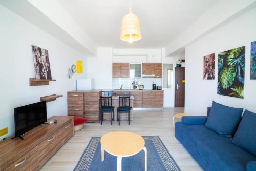 a living room with a blue couch and a table at Rezident Eforie Nord in Eforie Nord