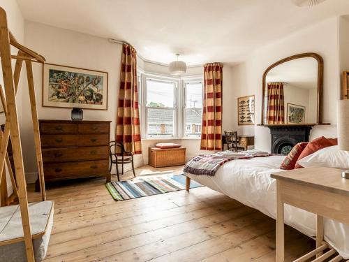 een slaapkamer met een bed, een dressoir en een spiegel bij Pass the Keys Characterful 4 bed home in central Exeter in Exeter