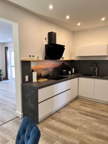 a kitchen with white cabinets and a black counter top at Ferienwohnungen Albarts by Mountain apart in Wernigerode