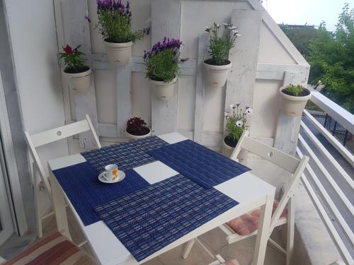 una mesa y sillas en un balcón con macetas en Apartment with two rooms near the beach en Asprovalta
