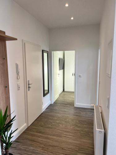 an empty hallway with white walls and wood floors at Ferienwohnungen Albarts by Mountain apart in Wernigerode