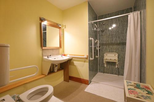 a bathroom with a shower and a toilet and a sink at Green Hope Guest House in Ellemford