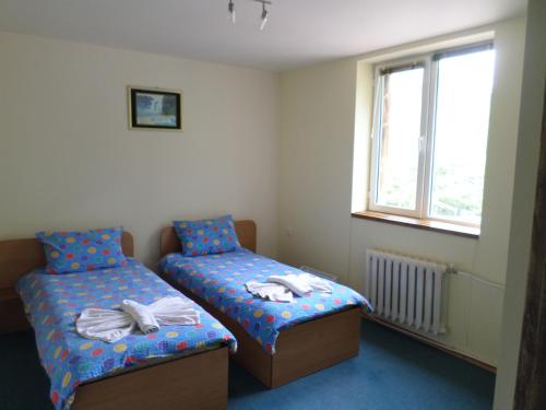 Cette chambre comprend 2 lits jumeaux et une fenêtre. dans l'établissement Семеен Хотел "При Мечо", à Monastère de Rila