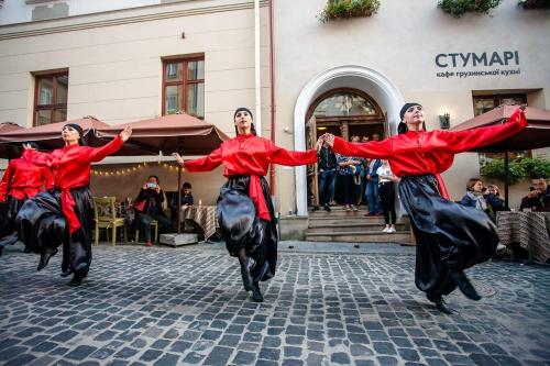 a group of three men in red performing a dance at Optima Collection Medievale Lviv in Lviv